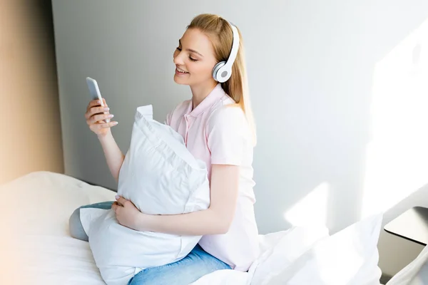 Mujer Bonita Sonriente Auriculares Inalámbricos Con Teléfono Inteligente Dormitorio — Foto de Stock