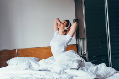 Kendini izole ederken kulaklıkla müzik dinleyen mutlu kız.