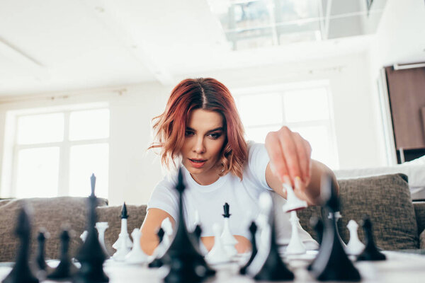 beautiful girl playing chess on self isolation, selective focus