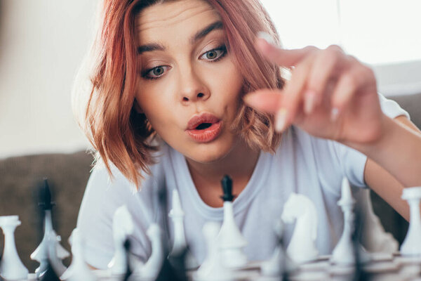 beautiful emotional girl playing chess on self isolation, selective focus