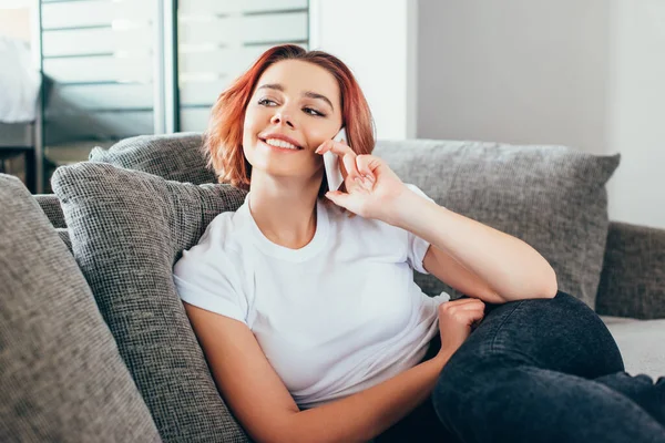 Chica Feliz Hablando Teléfono Inteligente Mientras Está Sentado Sofá Durante — Foto de Stock