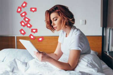 Karantinada kalp işaretleri olan dijital tablet kullanan güzel genç bir kadın. 