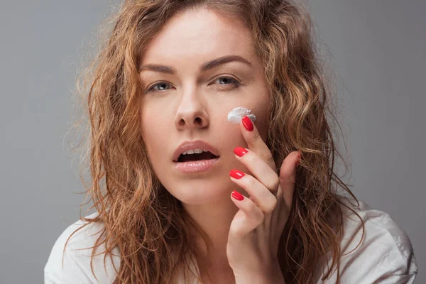 Woman applying face cream — Stock Photo
