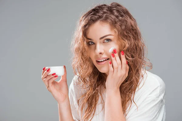 Frau trägt Gesichtscreme auf — Stockfoto