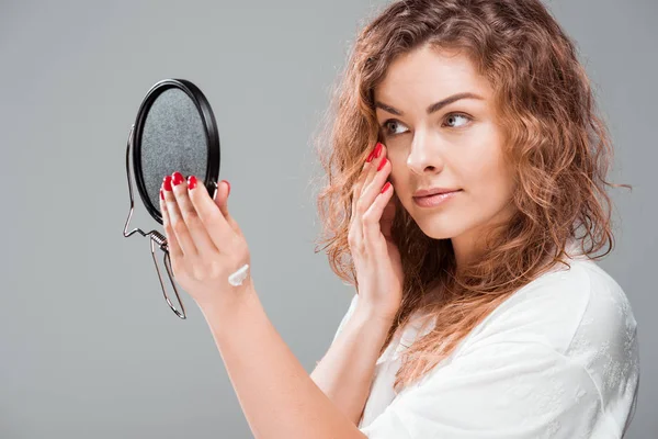 Mujer aplicando crema facial - foto de stock