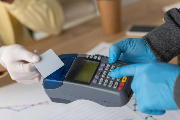 Vista cortada do homem de negócios segurando cartão de crédito perto do homem de entrega com terminal de pagamento — Fotografia de Stock