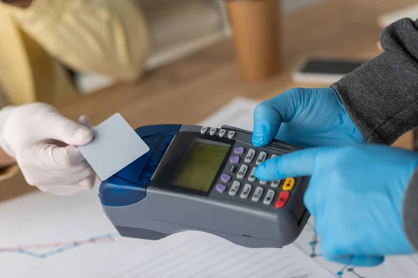 Vue recadrée de l'homme d'affaires détenant une carte de crédit près du livreur avec terminal de paiement — Photo de stock