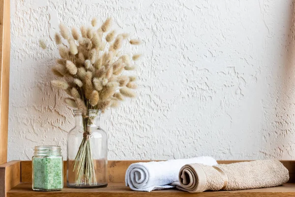 Mensola in legno con catkins fioriti, rotoli di tovagliolo e sale marino verde in vaso — Foto stock