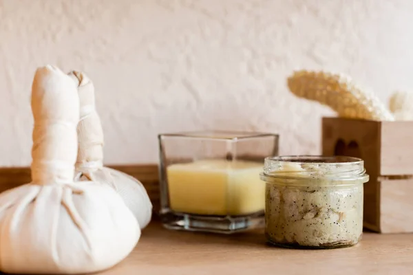 Selective focus of herbal bags near clay mask in jar and candle — Stock Photo