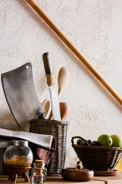 Cuillères et couteaux en bois près de fruits juteux, herbes et épices en bouteilles — Photo de stock