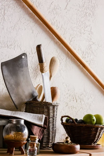 Wooden spoons and knifes near juicy fruits, herbs and spice in bottles — Stock Photo
