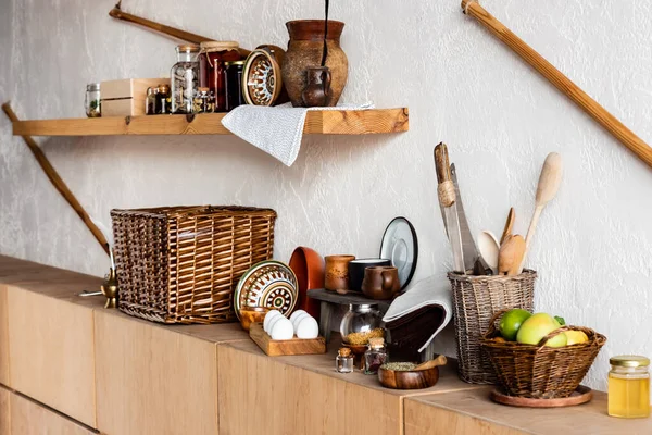 Tazas de arcilla y cuencos cerca de cuchillos huevos crudos, hierbas, especias y frutas sabrosas - foto de stock