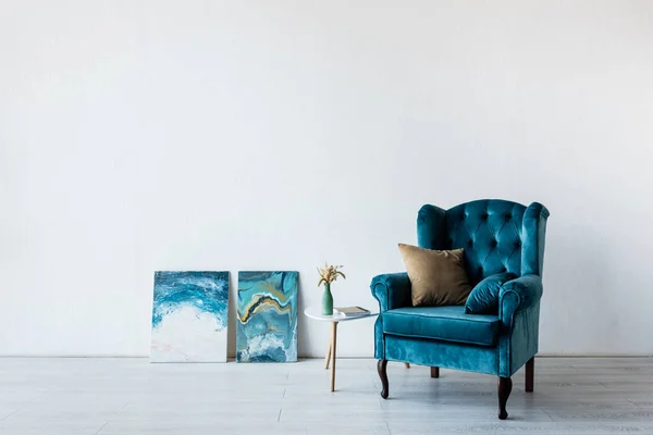 Bequeme Sessel in der Nähe von Vase auf Couchtisch und Gemälde im Wohnzimmer — Stockfoto