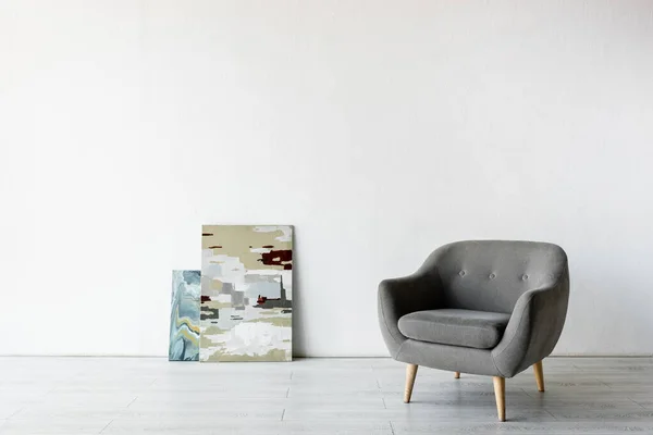 Comoda poltrona vicino ai dipinti in soggiorno — Foto stock