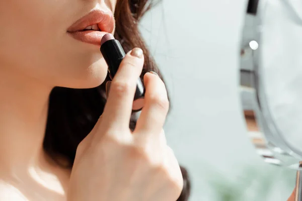 Vista recortada de la mujer usando lápiz labial y espejo en casa — Stock Photo