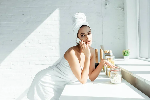 Seitenansicht der schönen Frau in Handtüchern im Gespräch auf dem Smartphone in der Küche — Stockfoto