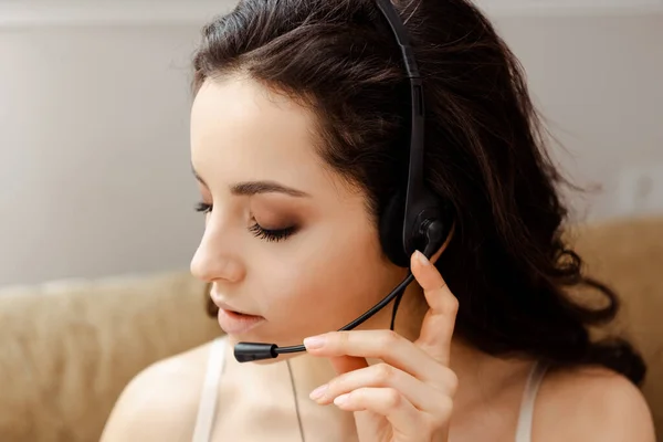 Attractive girl in lingerie talking with headset — Stock Photo