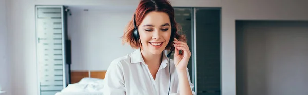 Smiling female freelancer using headset to work from home on self isolation, horizontal crop — Stock Photo