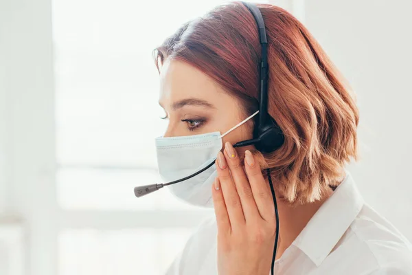 Freiberuflerin in medizinischer Maske arbeitet mit Headset von zu Hause aus an der Selbstisolation — Stockfoto