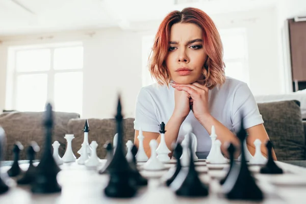 Вдумчивая девушка играет в шахматы на самоизоляции, избирательный фокус — стоковое фото