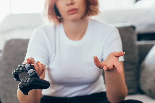 KYIV, UKRAINE - 15 de abril de 2020: visão recortada da menina triste jogando videogame com joystick em casa no auto-isolamento — Fotografia de Stock
