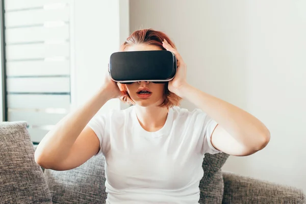 Menina emocional usando fone de ouvido realidade virtual em casa em quarentena — Fotografia de Stock