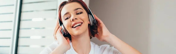 Chica feliz escuchando música con auriculares en casa durante la cuarentena - foto de stock