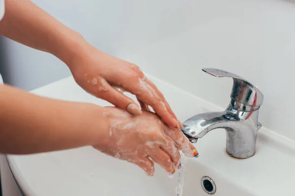 Обрізаний вид дівчини, що миє руки з піною на карантині — стокове фото