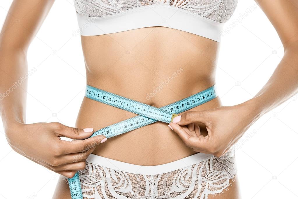 woman measuring waistline with measuring tape
