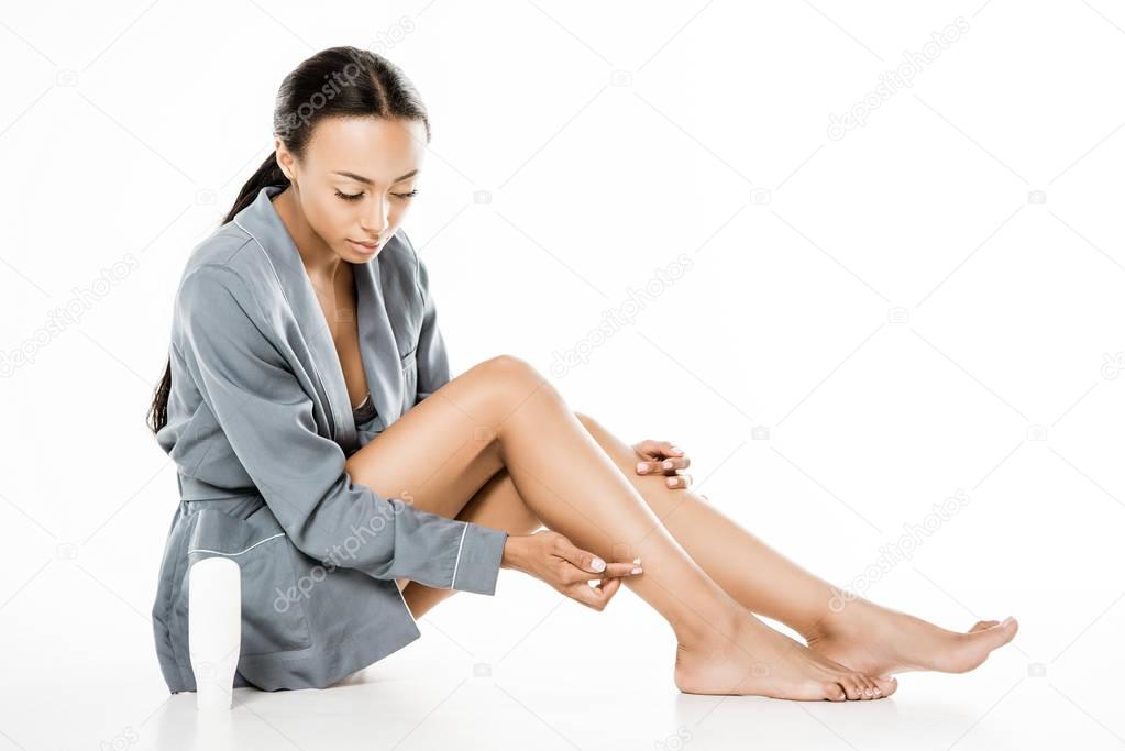 african american woman applying body cream