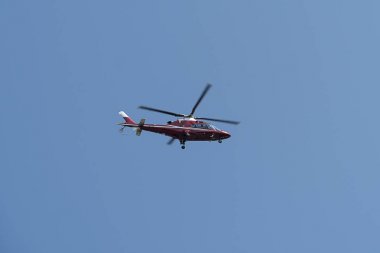 Mavi gökyüzünde uçan helikopter.