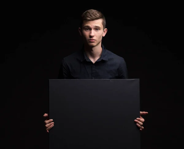 Jovem homem feliz mostrando apresentação, apontando no cartaz sobre g — Fotografia de Stock