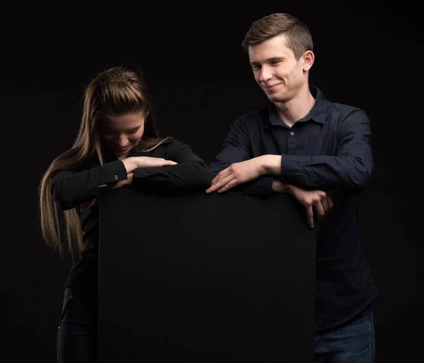 Νεαρό ζευγάρι ευτυχισμένο προβολή παρουσίασης επισημαίνοντας σχετικά με πλακάτ — Φωτογραφία Αρχείου