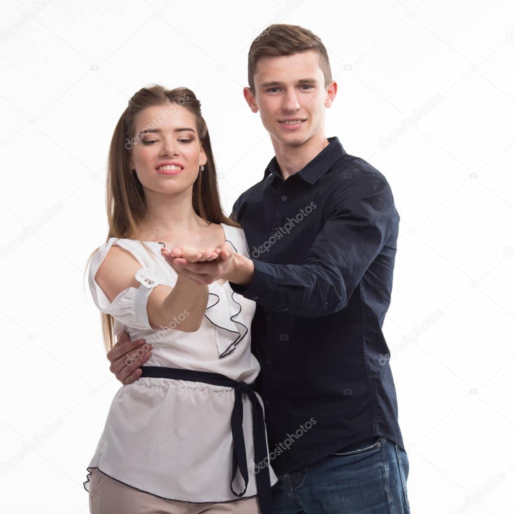Young happy couple showing presentation pointing on placard