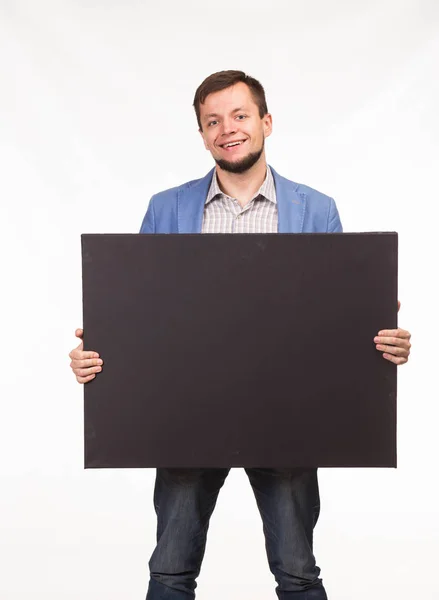 Joven hombre feliz mostrando la presentación, señalando en el cartel —  Fotos de Stock