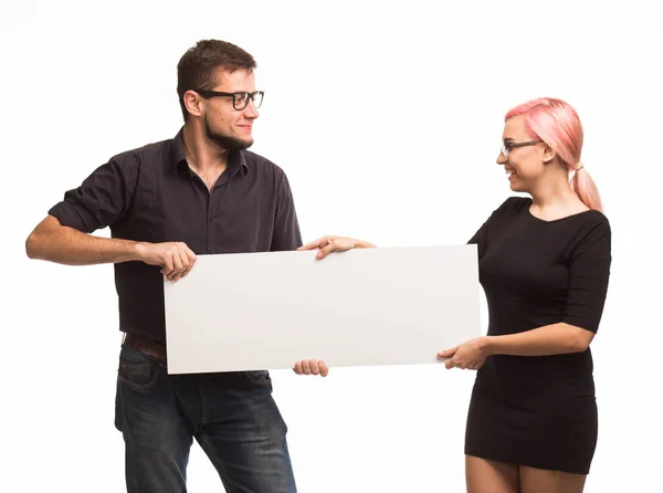 Молода грайлива пара показує презентацію, що вказує плакат — стокове фото