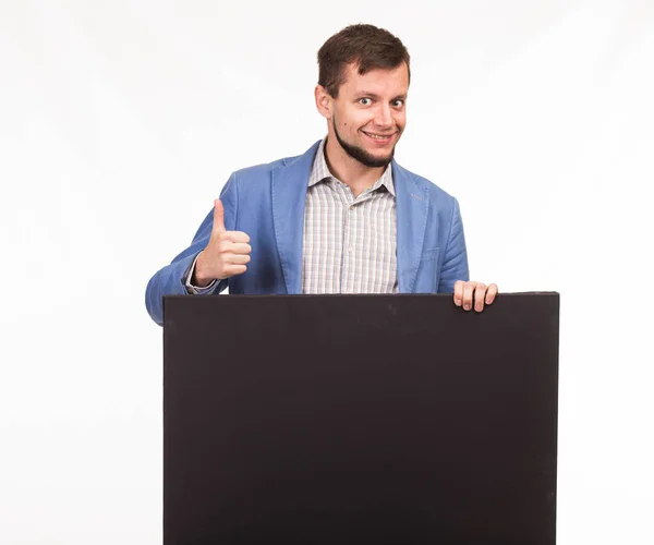 Joven hombre feliz mostrando la presentación, señalando en el cartel — Foto de Stock