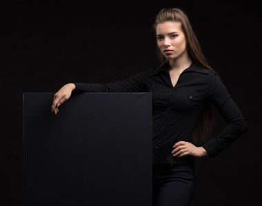 Sunu gösterilen, afiş üzerinde işaret eden genç seksi kadın