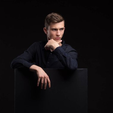 Sunu gösterilen, afiş üzerinde işaret eden genç seksi adam