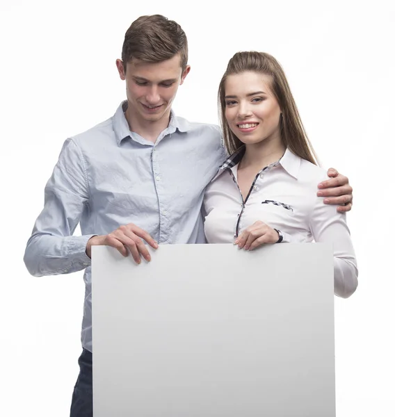 Giovane coppia felice mostrando presentazione puntando sul cartello — Foto Stock