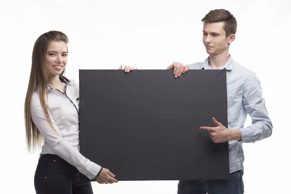 Giovane coppia felice mostrando presentazione puntando sul cartello sopra — Foto Stock
