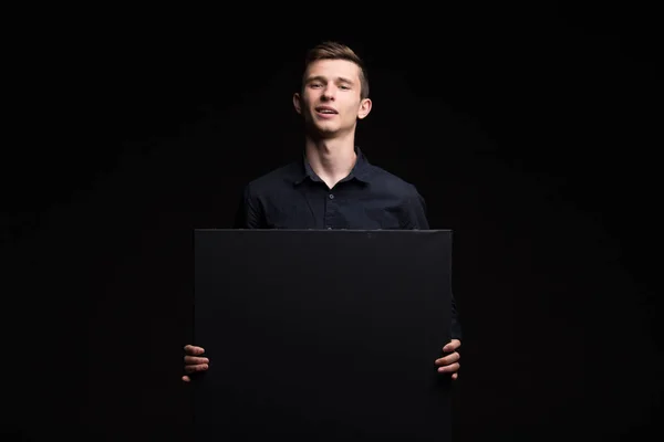 Jovem homem feliz mostrando apresentação, apontando no cartaz sobre g — Fotografia de Stock