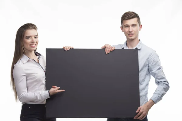 Joven feliz pareja mostrando la presentación señalando en el cartel sobre — Foto de Stock