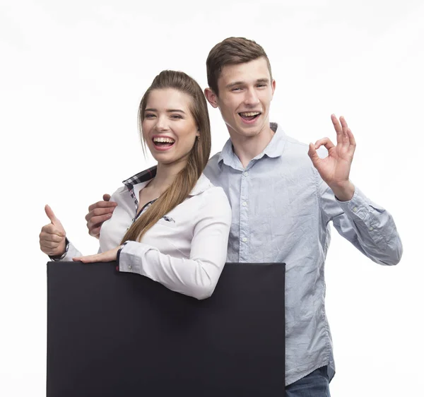 Молода щаслива пара показує презентацію, вказуючи на плакат — стокове фото