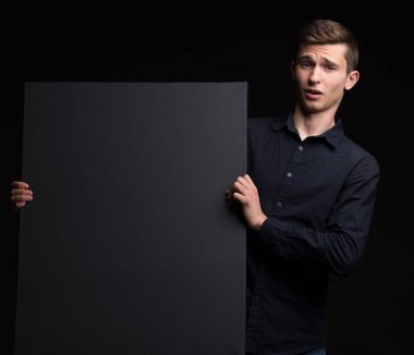 Genç sunu gösterilen, afiş üzerinde işaret eden adam şaşırttı