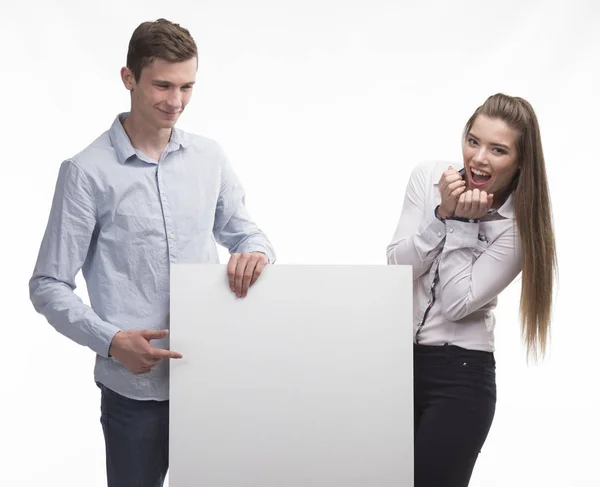 Молода щаслива пара показує презентацію, вказуючи на плакат — стокове фото