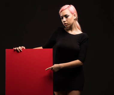 Sunu gösterilen, afiş üzerinde işaret eden genç seksi kadın