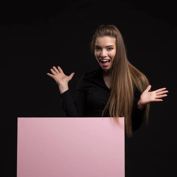 Joven mujer animada mostrando presentación, señalando en cartel — Foto de Stock