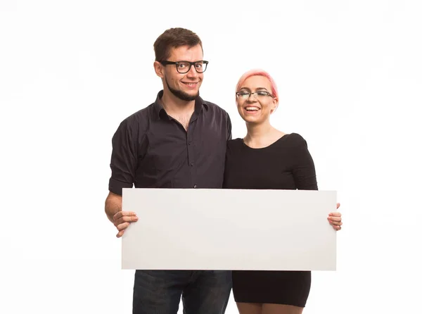 Unga lyckliga paret visar presentationen pekar plakat — Stockfoto