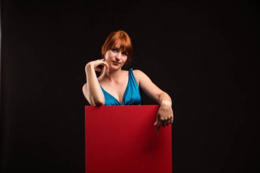 Sunu gösterilen, afiş üzerinde işaret eden genç seksi kadın